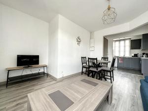 uma sala de estar com um sofá e uma mesa em appartement au 1er étage avec accès indépendant em Saint-Denis