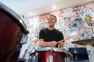a man playing drums in front of a wall at Safestay Pisa Centrale in Pisa