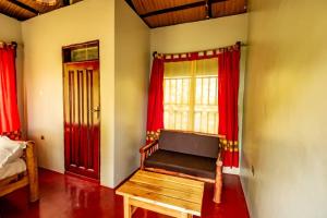 a room with a bench in a room with red curtains at Mise cave lodge in Kapchorwa