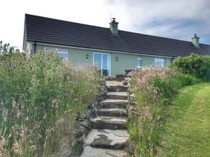 a house with stairs leading up to it at Causeway Coast Country Cottage, Pet-friendly in Ballycastle