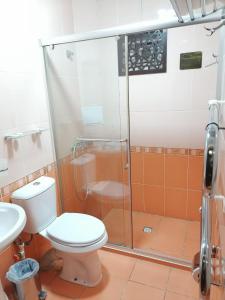 a bathroom with a toilet and a glass shower at Sarbon Plaza Hotel in Bukhara