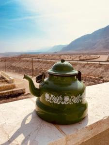 een groene theepot bovenop een richel bij בין הר ובין ים in Ovnat