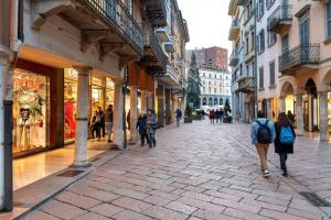 un grupo de personas caminando por una calle de la ciudad en Il Rifugio degli Artisti en Varese