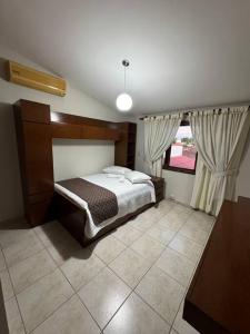 - une chambre avec un lit et une grande fenêtre dans l'établissement Hermosa casa amplia en zona residencial, à Santa Cruz de la Sierra