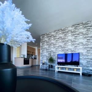 a living room with a tv and a stone wall at Highrise Horizon Penthouse in Budapest