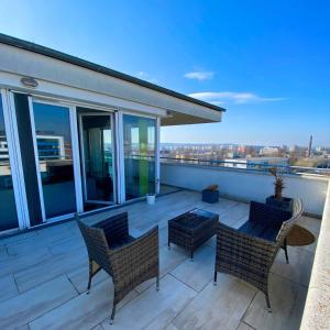 a patio with chairs and a table on a balcony at Highrise Horizon Penthouse in Budapest +8 photos
