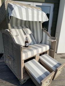 einen Stuhl mit einer Flasche Bier auf einer Veranda in der Unterkunft Ferienhaus Fischkopf in Büsum