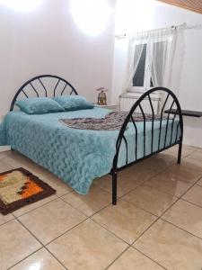 a bedroom with a bed with a blue comforter at Casa da Oliveira in Pegarinhos