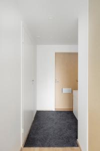 ein leeres Zimmer mit weißen Wänden und einer Tür in der Unterkunft Sea View Design Studio near metro in Espoo