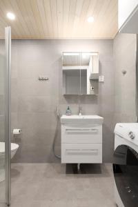 ein Badezimmer mit einem weißen Waschbecken und einer Dusche in der Unterkunft Sea View Design Studio near metro in Espoo