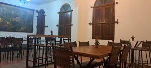 une salle à manger avec des tables et des chaises en bois dans l'établissement Pousada Economic Pitangui, à Pitangui