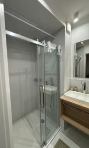 a bathroom with a glass shower and a sink at Apartament Whiteblue Dream 2 Kołobrzeg z ogródkiem & sauna & fitness & bawialnia dla dzieci in Kołobrzeg +17 photos