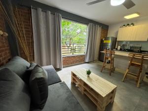 a living room with a couch and a table and a kitchen at Apartamentos Area Medica Imbanaco in Cali