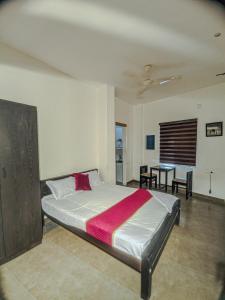 a bedroom with a large bed and a table at Raaha Residency in Kozhikode