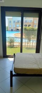 エル・アラメインにあるMarassi Verdi Pool View North Coastのベッドルーム1室(ベッド1台付)が備わります。プールの景色を望めます。 +22枚の写真