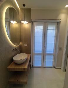 a bathroom with a bowl sink and a mirror at Su Coru 2 - Deluxe Studio in the Heart of Cagliari in Cagliari