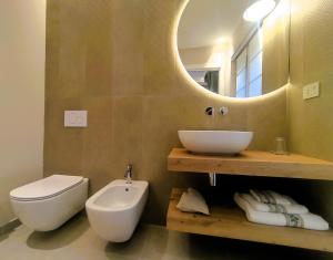 une salle de bain avec un lavabo, des toilettes et un miroir dans l'établissement Su Coru 2 - Deluxe Studio in the Heart of Cagliari, à Cagliari