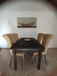 einen schwarzen Tisch mit zwei Stühlen und eine Schüssel Orangen in der Unterkunft Haus am Wanderweg in Niederdürenbach