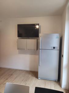 a white refrigerator in a room with a tv at Apartment Sweet Retreat in Dro