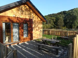 een houten hut met een picknicktafel ervoor bij Dolina Rosy in Ustrzyki Dolne