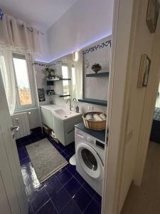 a bathroom with a sink and a washing machine at Lakehouse Enjoy in Verbania