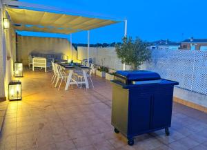 einen Mülleimer auf einer Terrasse mit einem Tisch und Stühlen in der Unterkunft Domuum Holidays -CASALMAR Family Home in Salou