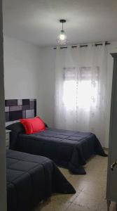 a bedroom with two beds and a window at Alojamiento Maria in Pinos Genil