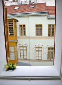a window view of a white house with a flower pot at Ruterra Apartment Charles Bridge in Prague
