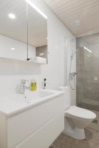 y baño blanco con aseo y ducha. en Modern LUXUS 3BR apartment Helsinki Tripla en Helsinki