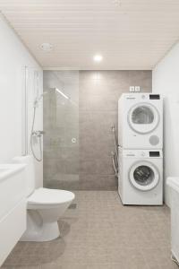 a bathroom with a toilet and a washing machine at Modern LUXUS 3BR apartment Helsinki Tripla in Helsinki