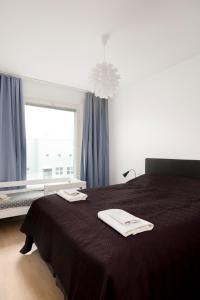 a bedroom with a black bed with two towels on it at Modern LUXUS 3BR apartment Helsinki Tripla in Helsinki