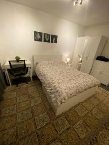 One Bedroom Flat in Chiswick W4 في لندن: غرفة نوم بسرير وطاولة ومكتب
