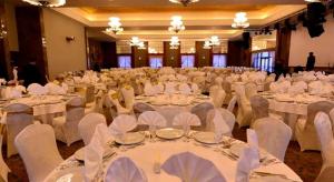 埃拉澤的住宿－Windyhill Hotel，一个带白色桌椅的大型宴会厅