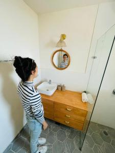 a woman standing in a bathroom with a sink at בין הר ובין ים in Ovnat +26 photos