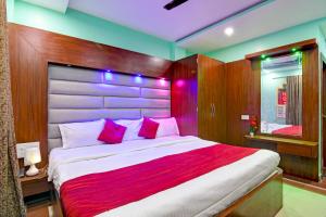 a bedroom with a large bed with pink pillows at Hotel Ashray Near Temple & Beach By Morservices in Puri