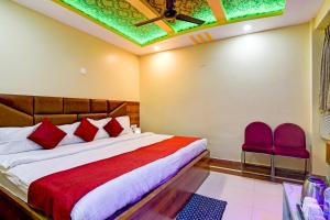 a bedroom with a bed and two red chairs at Hotel Ashray Near Temple & Beach By Morservices in Puri