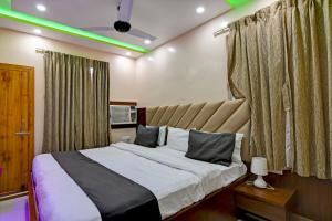 a bedroom with a large bed with green lighting at Hotel Ashray Near Temple & Beach By Morservices in Puri