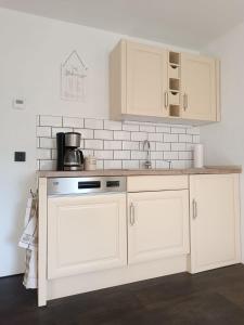 a kitchen with white cabinets and a counter top at Haus am Wanderweg in Niederdürenbach