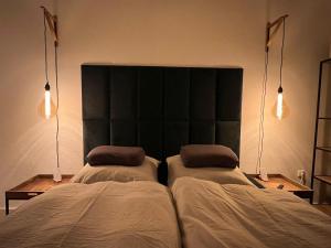 two beds in a bedroom with two lights on them at 100m E-Ladestation - max 4 pers - Düsseldorf - Ruhrgebiet - Pilgerstätte in Velbert