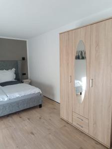 a bedroom with a bed and a dresser with a mirror at Haus am Wanderweg in Niederdürenbach