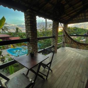 una veranda in legno con tavolo e sedie su una terrazza di Hostel do Ceu a Pipa