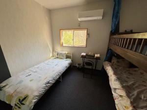 Tosa的住宿－Hostel John Mang ゲストハウス ジョン，小房间设有一张床和一张双层床