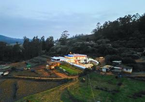 una vista aérea de una casa en una colina en Silent Retreat Ooty Farm Resort by VOYE HOMES en Ooty