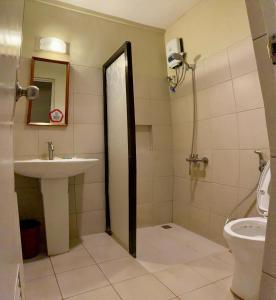 ein Bad mit einem Waschbecken und einem WC in der Unterkunft Asiatel Airport Hotel in Manila
