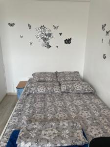 ブカレストにあるStudio Ianisの蝶が壁に描かれたベッドルームのベッド1台