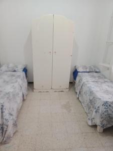 um quarto com duas camas e um armário em Maison pied dans l'eau -Bainem Alger em Baïnem Falaise