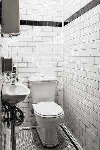 Baño blanco con aseo y lavamanos en Darlo Bar Darlinghurst en Sídney