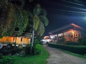 een huis 's nachts met een palmboom ervoor bij ระเบียงดอยโฮมสเตย์ in Wiang Pa Pao