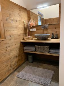 uma casa de banho com paredes de madeira e um lavatório em Nock Chalets em Afritz