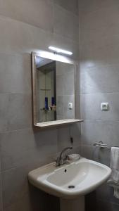 La salle de bains est pourvue d'un lavabo et d'un miroir. dans l'établissement Casa das Floreiras - City Center Apartment, à Horta